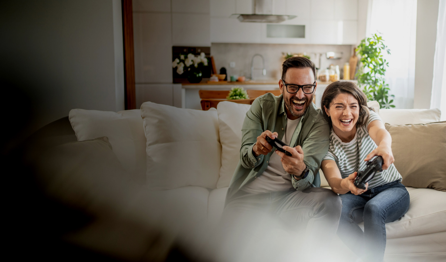 Couple sitting on couch playing video games